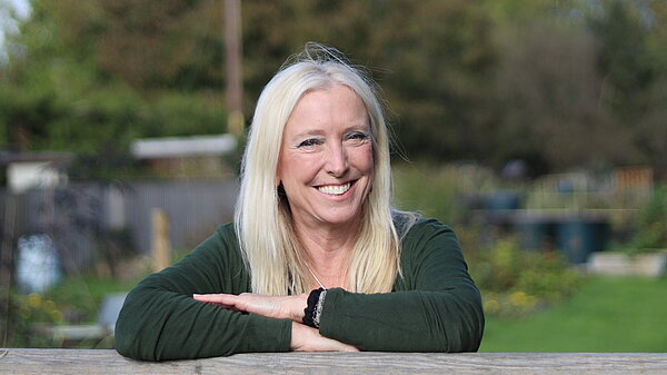 Roz Savage leaning against a fence at Kemble Community Gardens