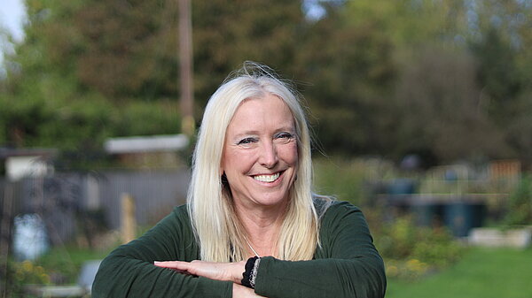 Roz Savage leaning against a fence at Kemble Community Gardens